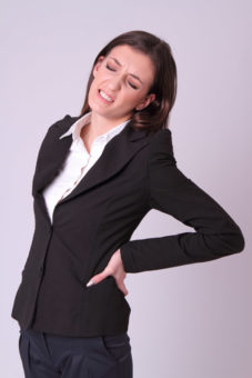急性腰痛、ギックリ腰で腰を抑える女性